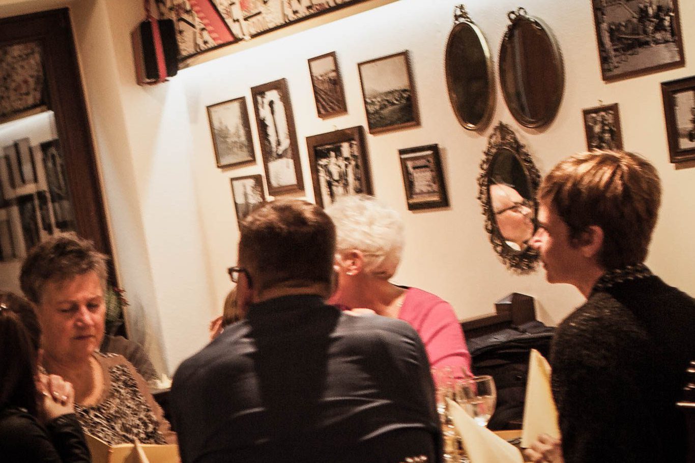 Gastraum-Gästehaus mit historischen Fotos und Gästen bei Event.