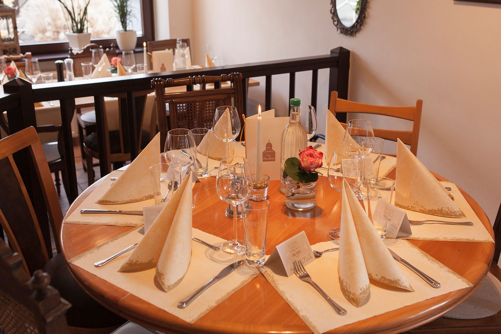 Festlich eingedeckter runder Tisch auf der Empore des Gastraumes