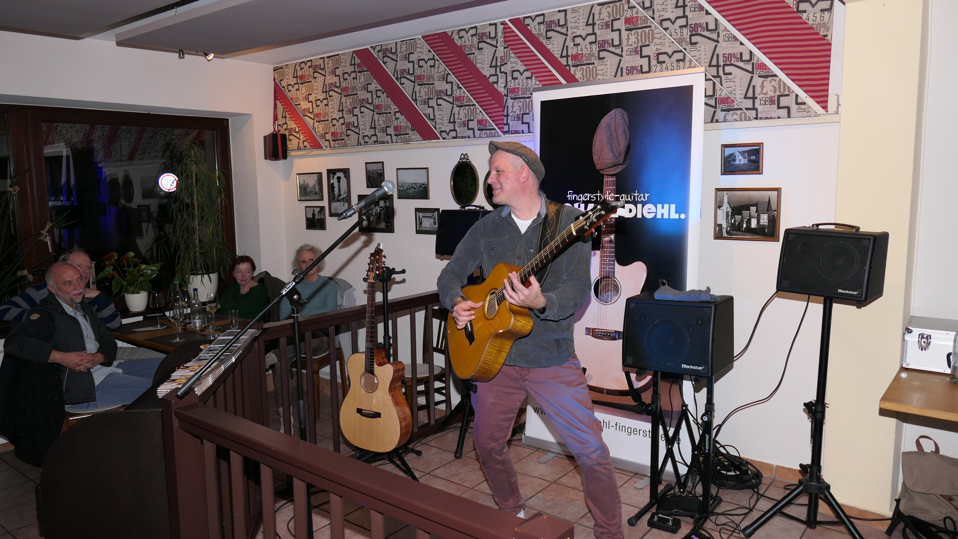 Michael Diehl mit Gitarre auf der Bühne des "Kirchleins"